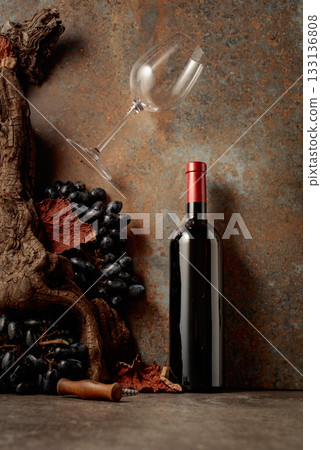 Bottle of red wine with blue grapes on a rusty background. Bottle of red wine with blue grapes on a rusty background. 133136808