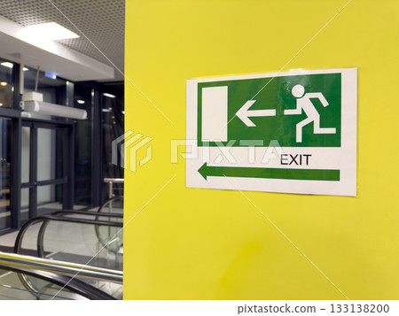 Sign depicting person running away and arrow pointing toward building exit. Concept for building safety and rescue in event of emergency or fire. Universal accident rescue sign Sign depicting person running away and arrow pointing toward building exit. Concept for building safety and rescue in event of emergency or fire. Universal accident rescue sign 133138200