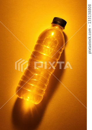 A glowing plastic bottle in warm orange tones symbolizing heat and dehydration. Ideal for topics like summer thirst, environmental awareness, or plastic pollution in hot weather contexts. 133138808