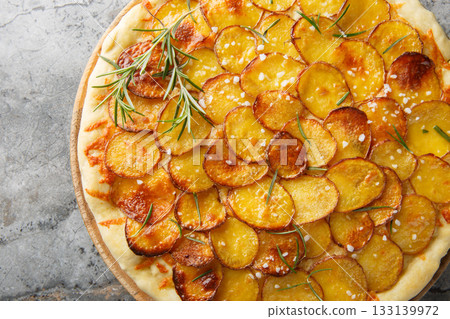Fresh baked pizza with potato vegetables and rosemary closeup on the wooden board. Horizontal top view 133139972