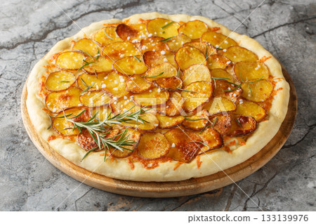 Vegetarian Potato rosemary pizza sprinkled with coarse salt and baked until crispy close-up on a wooden board. Horizontal Vegetarian Potato rosemary pizza sprinkled with coarse salt and baked until crispy close-up on a wooden board. Horizontal 133139976