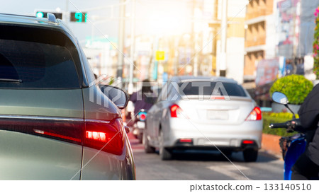 Rear side of dark green car with turn on brake light. Many car prepar for start to go from green light signal. Blurred of town at day time. Rear side of dark green car with turn on brake light. Many car prepar for start to go from green light signal. Blurred of town at day time. 133140510