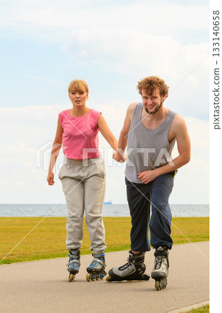 Man encourage woman to do rollerblading 133140658