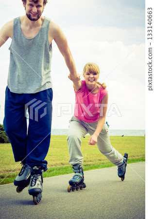 Man encourage woman to do rollerblading 133140663