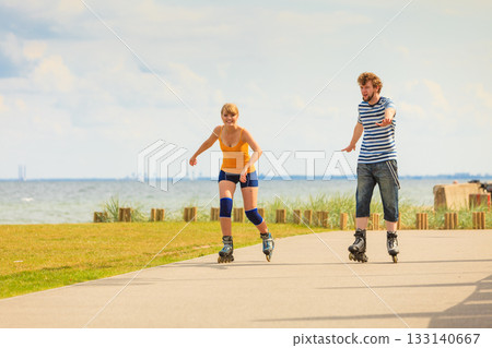 Young couple on roller skates riding outdoors 133140667