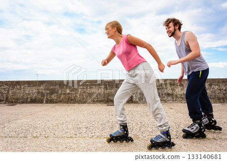 Active young people friends rollerskating outdoor. 133140681