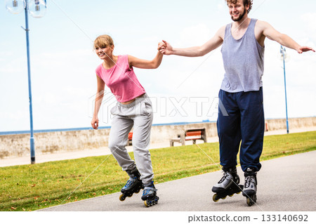 Active young people friends rollerskating outdoor. 133140692