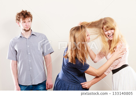 Aggressive mad women fighting over man. 133140805