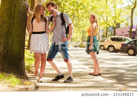 Jealous girl looking at flirting couple outdoor. Jealous girl looking at flirting couple outdoor. 133140815