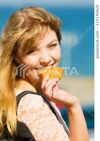 Young woman eating croissant food outdoor. Young woman eating croissant food outdoor. 133140820