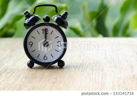Alarm clock pointing at 12pm with customizable background space for text or ideas. Time concept. Alarm clock pointing at 12pm with customizable background space for text or ideas. Time concept. 133141716