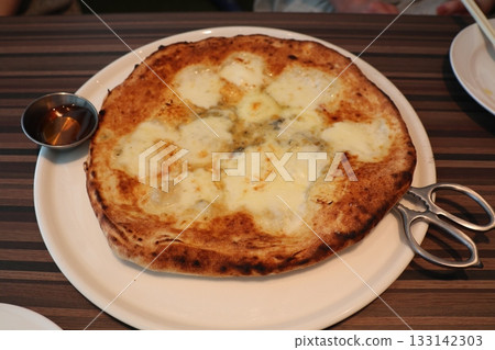 A dish that shines with melted cheese and sweet accents — the moment you cut the freshly baked pizza with scissors A dish that shines with melted cheese and sweet accents — the moment you cut the freshly baked pizza with scissors 133142303
