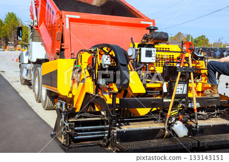 Asphalt paving machine working during road construction Asphalt paving machine working during road construction 133143151