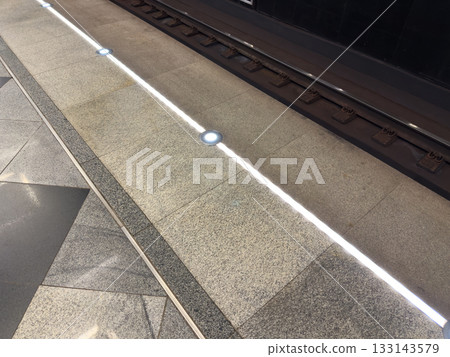 Edge of subway platform has lighted line to ensure social distancing when subway train arrives. Do not approach platform edge. Keep safe distance on track. Platform safety equipment 133143579