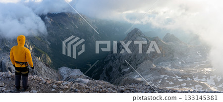 Hiker on a mountain summit enjoying beautiful alpine scene during sunrise, Slovenia Hiker on a mountain summit enjoying beautiful alpine scene during sunrise, Slovenia 133145381