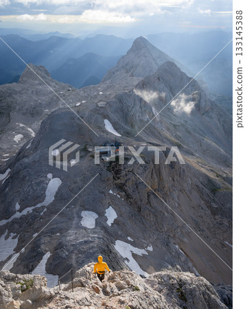 Vertical shot of hiker descending through beautiful alpine terrain, Slovenia Vertical shot of hiker descending through beautiful alpine terrain, Slovenia 133145388