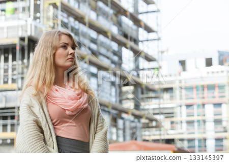 Woman on front of new house building Woman on front of new house building 133145397