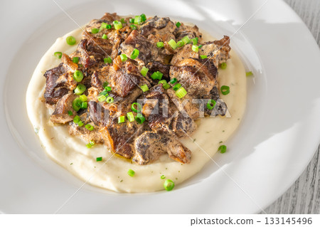 Braised meat and mushroom topping over creamy mashed potato served on white plate Braised meat and mushroom topping over creamy mashed potato served on white plate 133145496