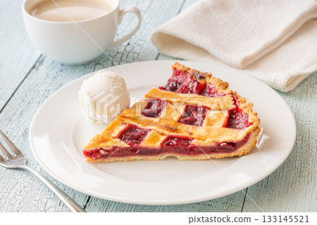 Cherry pie slice with melting ice cream and coffee on white plate 133145521