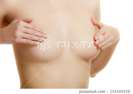 Woman examining her breasts for breast cancer 133145559