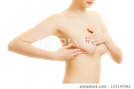 Woman examining her breasts for breast cancer 133145561