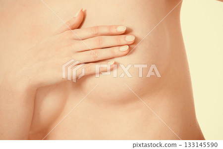 Woman covering her breast with hands Woman covering her breast with hands 133145590