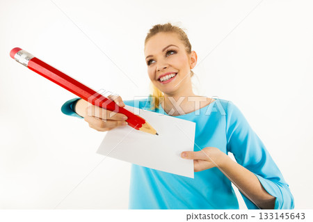 Woman with big pencil writing on paper Woman with big pencil writing on paper 133145643
