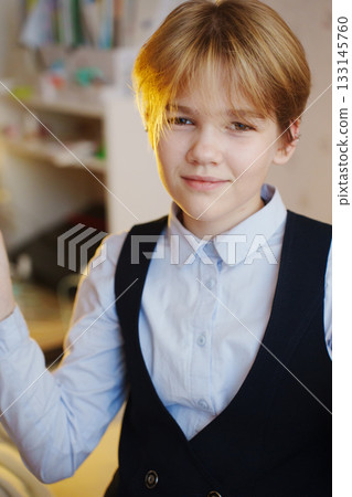 Boy in a stylish outfit holding a diffuser in a bright room 133145760