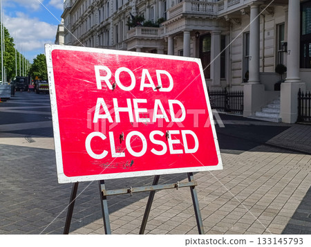 Road Ahead Closed sign on tripod in city street, traffic detour and roadworks warning Road Ahead Closed sign on tripod in city street, traffic detour and roadworks warning 133145793