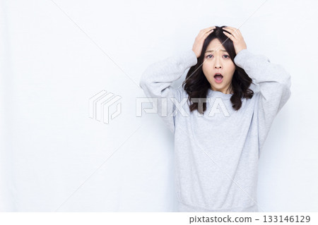 Surprised woman holding her head 133146129