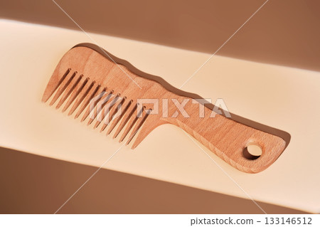 Wooden comb with shadow on beige background 133146512