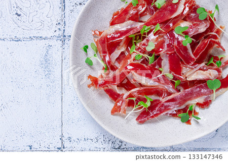 Ham of duck breast,dried duck fillet, with microgreens,plate, on a tiled table, Ham of duck breast,dried duck fillet, with microgreens,plate, on a tiled table, 133147346