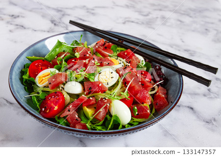 salad with fresh tuna, cherry tomatoes and quail eggs and avacado, served with chopsticks, salad with fresh tuna, cherry tomatoes and quail eggs and avacado, served with chopsticks, 133147357