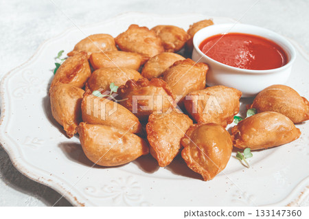 Fried mini chebureks, with sauce, on a decorative plate, hard light, no people, 133147360
