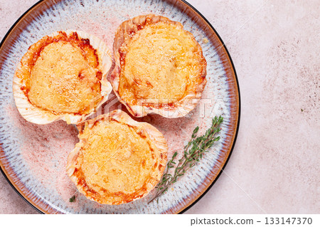 scallop, baked in shells, with cheese and spices, on a plate, homemade, 133147370