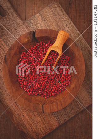 Bright red peppercorns, in a wooden bowl, with a small wooden tray, Bright red peppercorns, in a wooden bowl, with a small wooden tray, 133147382