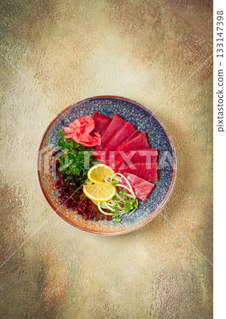 tuna sashimi with daikon and wakame salad, pickled ginger, in a bowl, 133147398