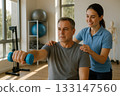 Male patient doing physiotherapy shoulder workout with therapist Male patient doing physiotherapy shoulder workout with therapist 133147560
