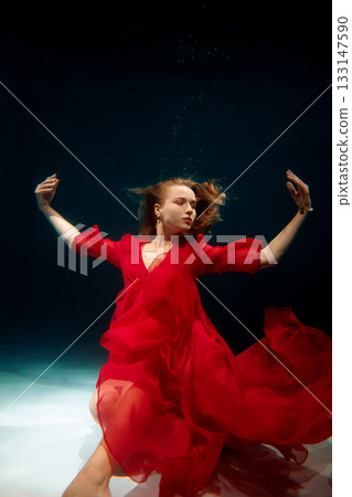 caucasian choreographer demonstrating underwater in red dress caucasian choreographer demonstrating underwater in red dress 133147590