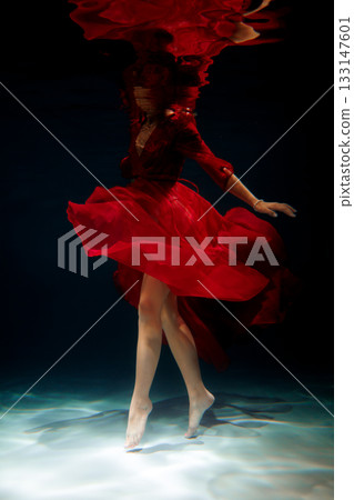 Styling in scarlet gown reflecting dim glistening ripples Styling in scarlet gown reflecting dim glistening ripples 133147601