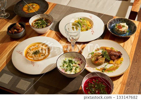 A Gourmet Dinner Spread with an Array of Vibrant Dishes Served on Beautifully Decorative Plates 133147682
