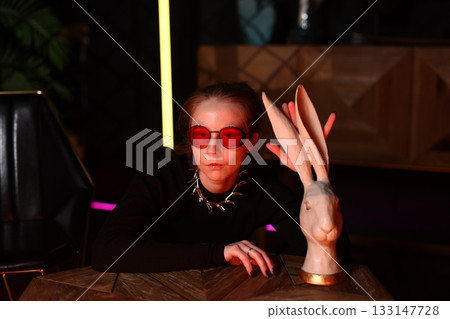 alternative artist gazes at ceramic sculpture, moody artist in black outfit inspects ceramic art 133147728