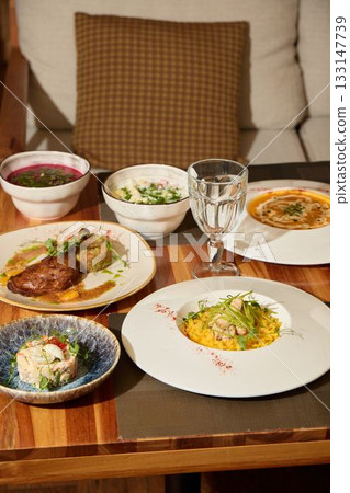 Experience a stunning gourmet meal presentation beautifully arranged on a rustic wooden table 133147739