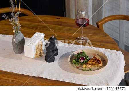 An Elegant Dining Table Setting beautifully arranged with a delightful Salad and fine Wine 133147771