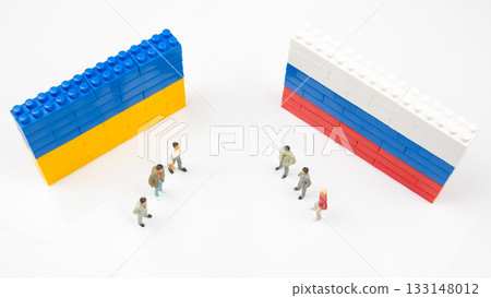 Miniature figurines stand between blocks walls designed with Ukrainian and Russian flag colors Miniature figurines stand between blocks walls designed with Ukrainian and Russian flag colors 133148012