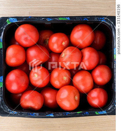 Top view of ripe red tomatoes in black crate. Top view of ripe red tomatoes in black crate. 133148196