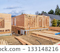 Wooden frame of new building with engineered lumber materials in front Wooden frame of new building with engineered lumber materials in front 133148216