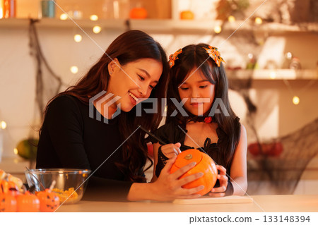 Halloween Fun: Mother and Daughter Carving Pumpkins Together Halloween Fun: Mother and Daughter Carving Pumpkins Together 133148394