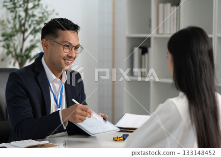 Friendly Insurance Advisor Explaining Options to Client Friendly Insurance Advisor Explaining Options to Client 133148452