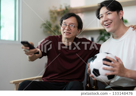 Family Bonding. Two men enjoying a soccer game on TV together. 133148476